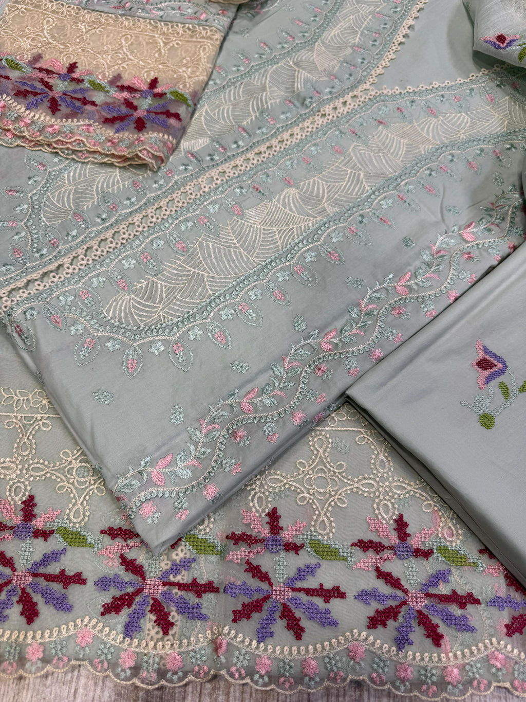 Crafted from premium cambric cotton, this piece features intricate embroidery on the front, back, and sleeves